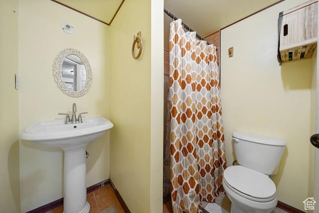 bathroom with toilet, tile patterned floors, baseboards, and curtained shower