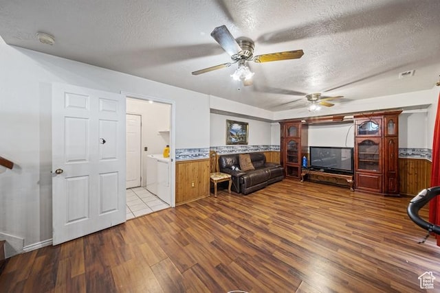 living area featuring wood finished floors, a textured ceiling, and ceiling fan