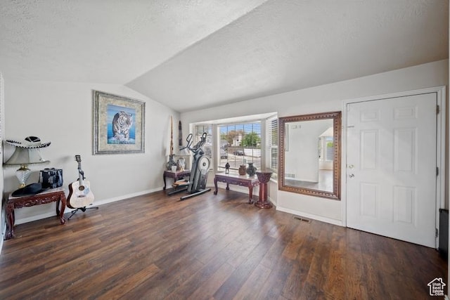 foyer with vaulted ceiling, baseboards, dark wood-type flooring, and a textured ceiling