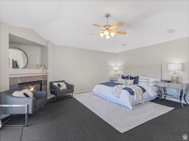 carpeted bedroom with a tile fireplace, lofted ceiling, ceiling fan, and baseboards
