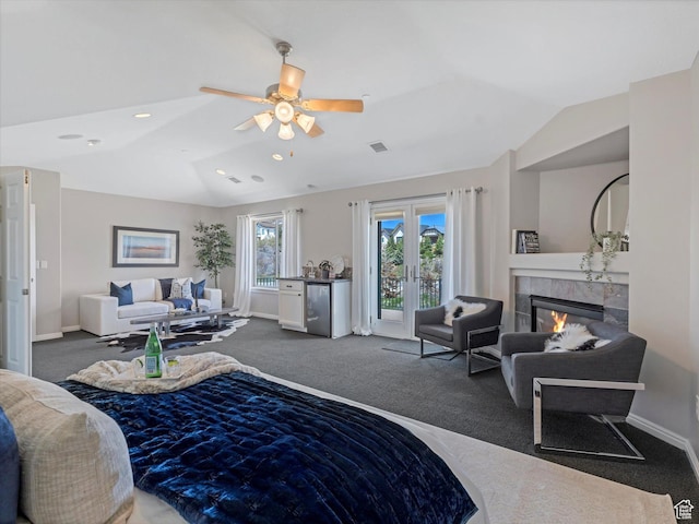bedroom with vaulted ceiling, carpet, access to exterior, baseboards, and a tile fireplace