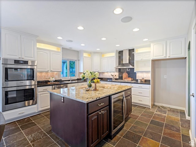 kitchen with wine cooler, wall chimney exhaust hood, stainless steel appliances, decorative backsplash, and recessed lighting