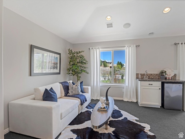 living area with wet bar, dark colored carpet, baseboards, and recessed lighting