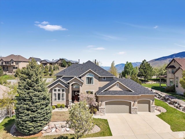 view of front facade with stucco siding, an attached garage, driveway, stone siding, and a mountain view