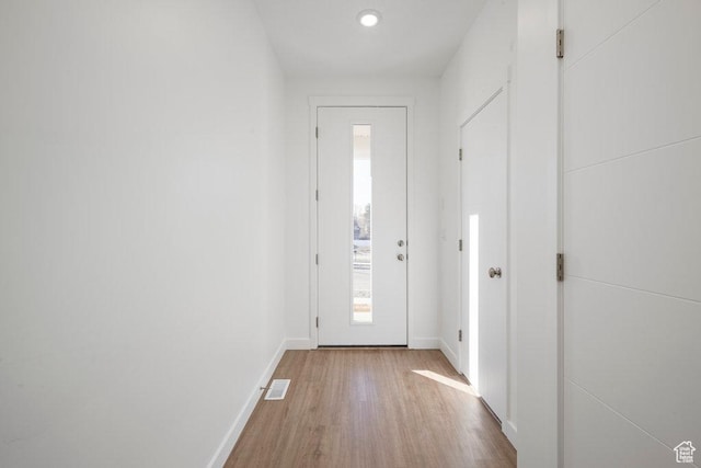 entryway featuring wood finished floors, baseboards, and recessed lighting