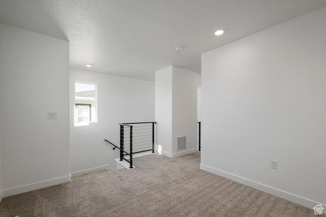 carpeted empty room featuring recessed lighting, baseboards, a textured ceiling, and a smoke detector