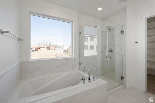 bathroom featuring a shower stall, a garden tub, marble finish flooring, and recessed lighting
