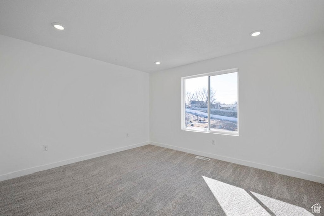 unfurnished room featuring carpet, recessed lighting, and baseboards