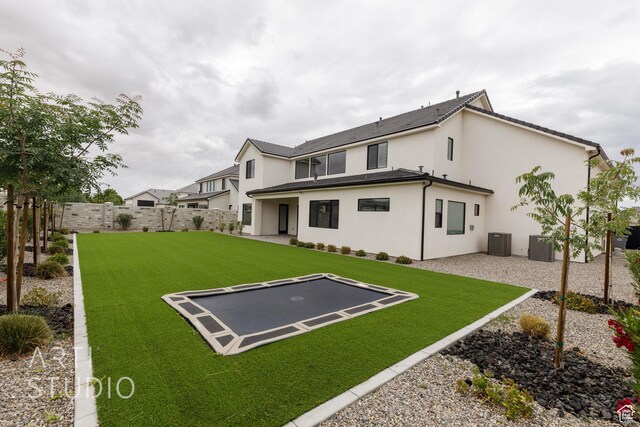 3855 S Kennedy Ln, Washington, UT 84780 - back of property with a trampoline, central air condition unit, stucco siding, and a patio