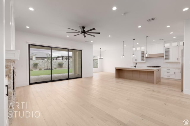 3855 S Kennedy Ln, Washington, UT 84780 - unfurnished living room featuring a ceiling fan, light wood-style floors, recessed lighting, a stone fireplace, and a sink
