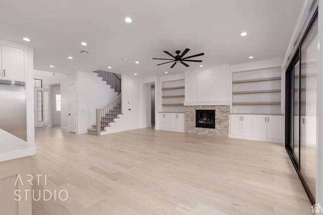 3855 S Kennedy Ln, Washington, UT 84780 - unfurnished living room featuring stairway, light wood-style floors, recessed lighting, ceiling fan, and a glass covered fireplace