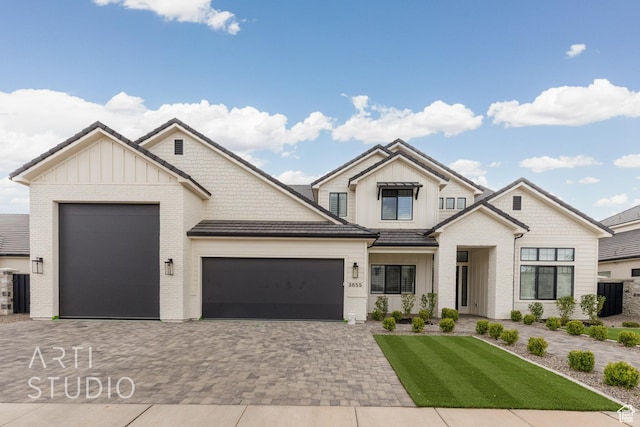 3855 S Kennedy Ln, Washington, UT 84780 - modern inspired farmhouse featuring board and batten siding, an attached garage, decorative driveway, and brick siding