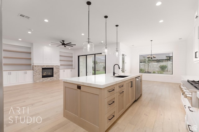 3855 S Kennedy Ln, Washington, UT 84780 - kitchen featuring a sink, light wood finished floors, stainless steel dishwasher, a glass covered fireplace, and recessed lighting