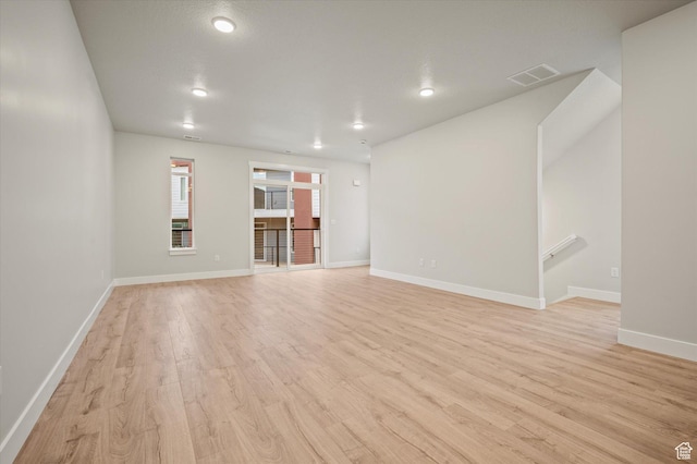 unfurnished living room with light wood finished floors, baseboards, and recessed lighting