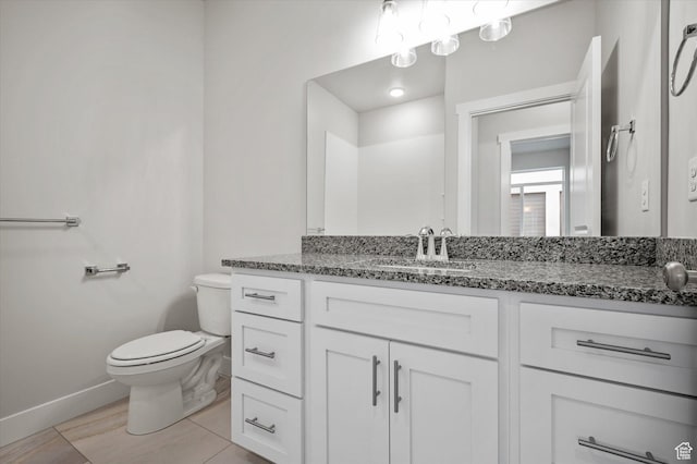 bathroom with toilet, baseboards, and vanity