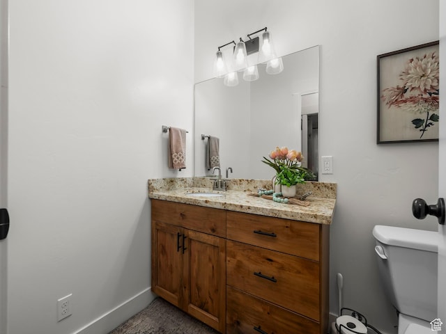 bathroom featuring vanity, toilet, and baseboards