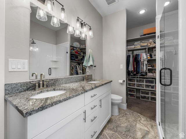 full bath with a shower stall, double vanity, a walk in closet, and toilet