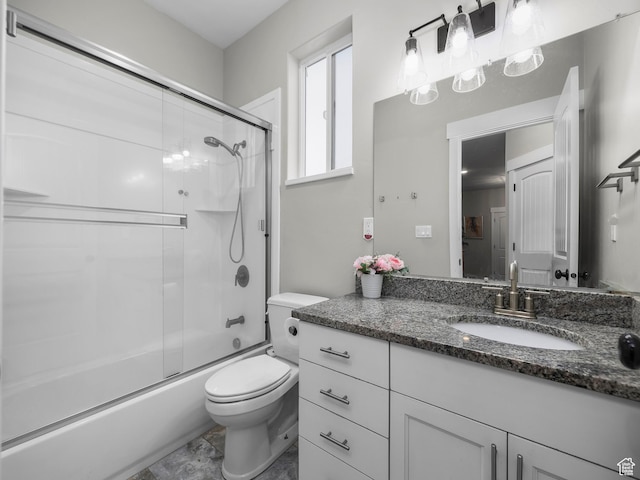 full bath with toilet, vanity, and bath / shower combo with glass door