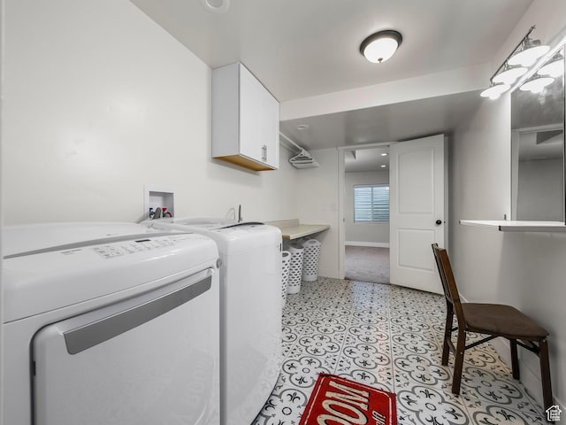 washroom featuring cabinet space, independent washer and dryer, baseboards, and light floors