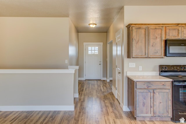 2351 E 370 N Unit 06, Spanish Fork, UT 84660 - kitchen with black appliances, light wood-style floors, light countertops, baseboards, and brown cabinets