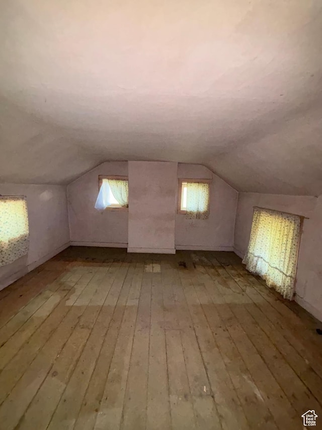bonus room featuring light wood-type flooring and vaulted ceiling