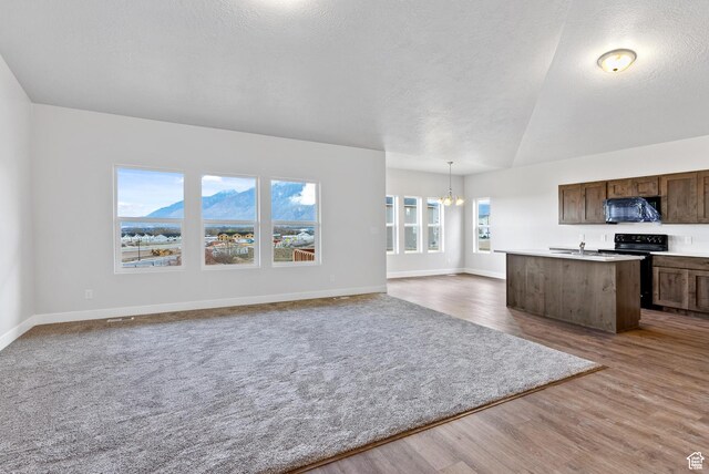 2363 E 370 N Unit 07, Spanish Fork, UT 84660 - kitchen featuring black appliances, a chandelier, open floor plan, a textured ceiling, and light countertops