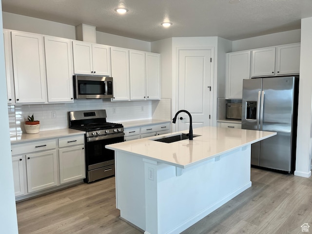 2055 S 4140 W, Taylor, UT 84401 - kitchen featuring appliances with stainless steel finishes, a sink, light wood-style flooring, and decorative backsplash