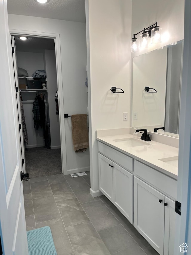2055 S 4140 W, Taylor, UT 84401 - bathroom featuring double vanity, a walk in closet, and baseboards