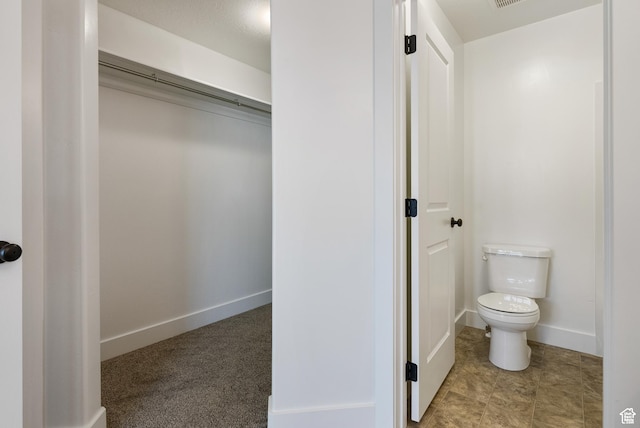 bathroom with toilet and baseboards