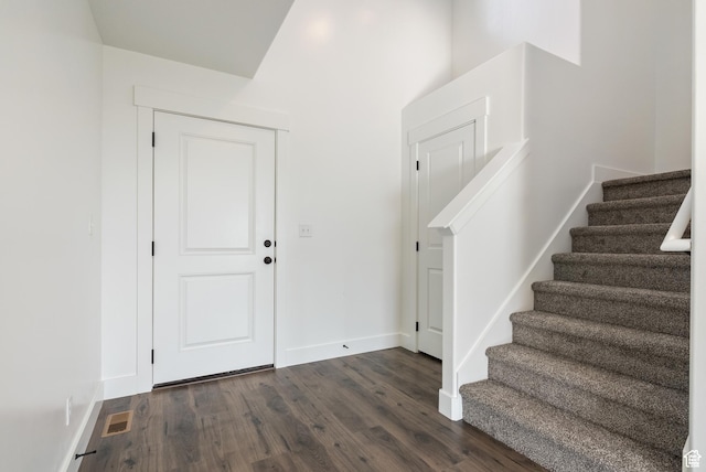entrance foyer featuring dark wood-style floors, stairway, and baseboards