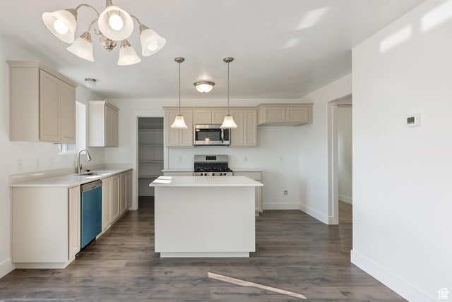 kitchen featuring appliances with stainless steel finishes, a sink, baseboards, and dark wood finished floors