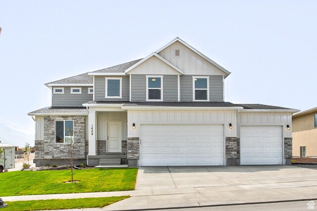 362 N 2350 E Unit 10, Spanish Fork, UT 84660 - view of front of home featuring stone siding, board and batten siding, driveway, a front lawn, and a garage