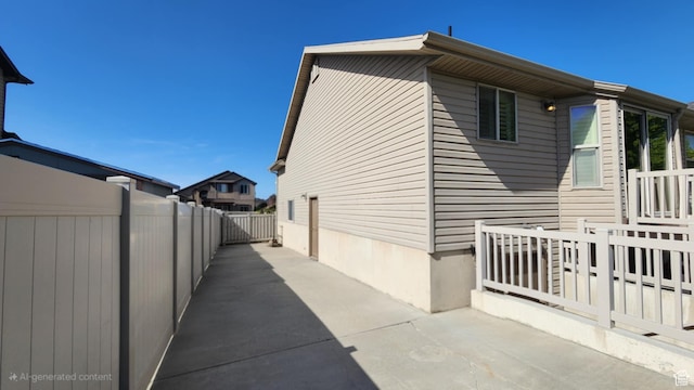 view of property exterior featuring fence and a patio
