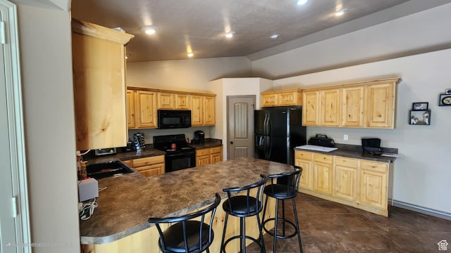 kitchen with black appliances, dark countertops, lofted ceiling, light brown cabinetry, and a sink