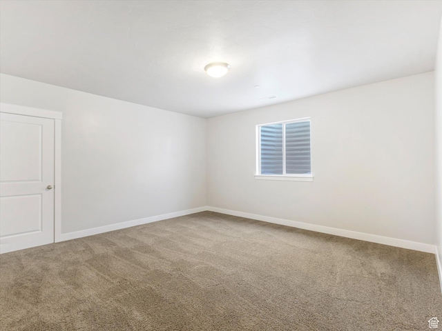 carpeted empty room featuring baseboards