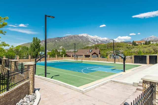 view of basketball court featuring community basketball court, a mountain view, and fence