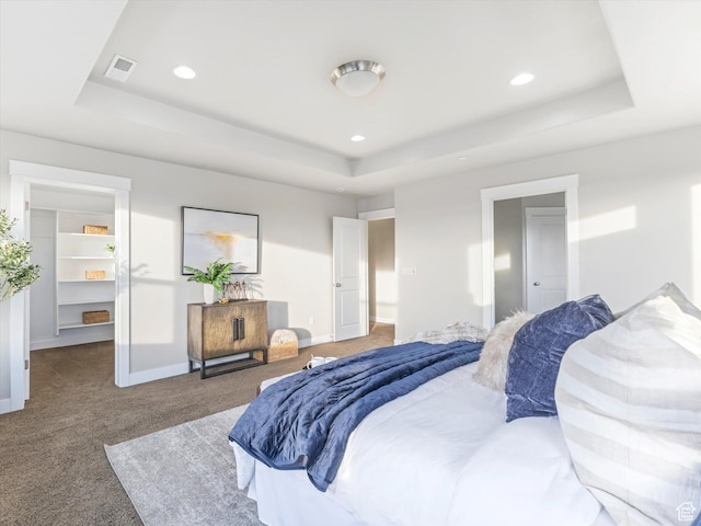 bedroom featuring a raised ceiling, carpet floors, baseboards, a spacious closet, and recessed lighting