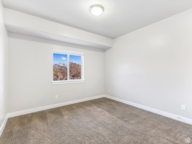 unfurnished room with carpet and baseboards