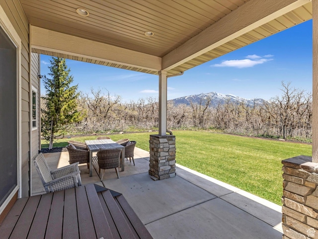 view of patio / terrace with outdoor dining space and a mountain view