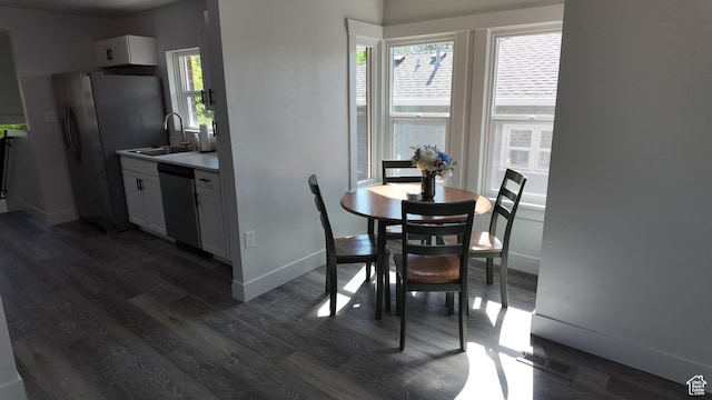 dining room featuring dark wood-style flooring and baseboards
