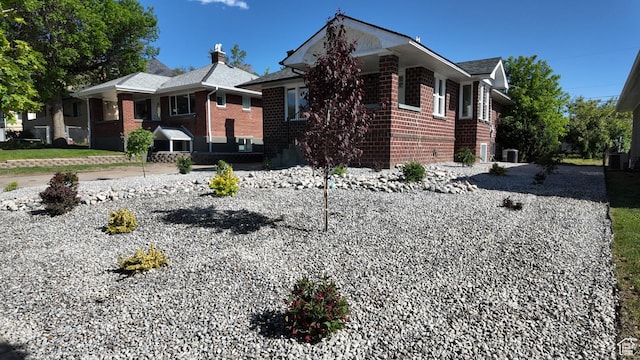 view of side of home with brick siding and central air condition unit