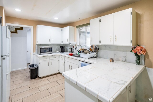 853 N 1250 W, Provo, UT 84604 - kitchen featuring stainless steel microwave, decorative backsplash, a sink, freestanding refrigerator, and white cabinetry