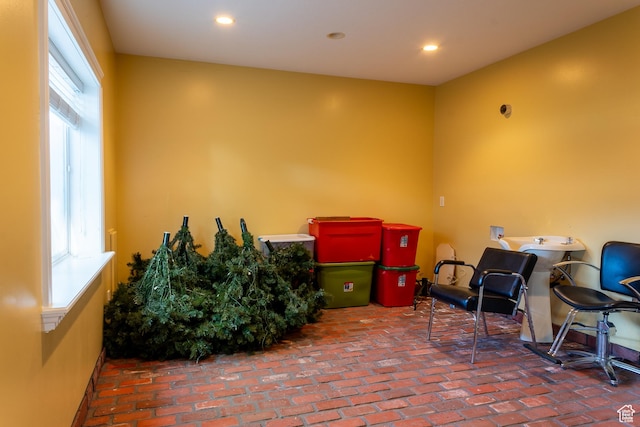 miscellaneous room with healthy amount of natural light, brick flooring, and recessed lighting