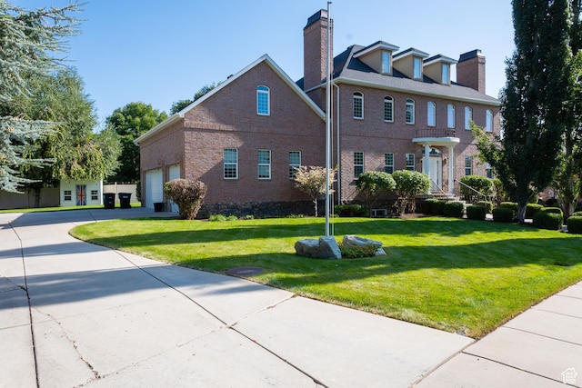 view of front of property with a front lawn, brick siding, and driveway