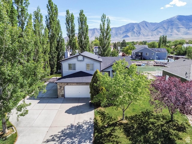 133 N Lakeview W Unit 39, Stansbury Park, UT 84074 - view of front of house featuring concrete driveway, a mountain view, stone siding, and a garage