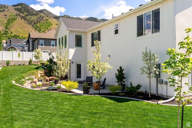 back of property with stucco siding, a patio area, and a mountain view
