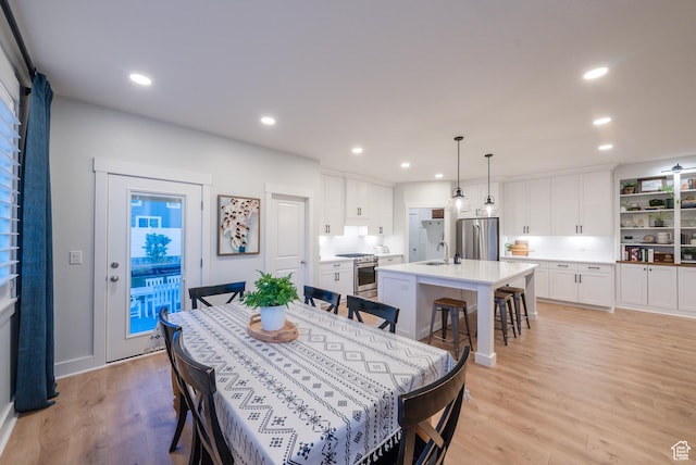 dining area with light wood-style floors and recessed lighting