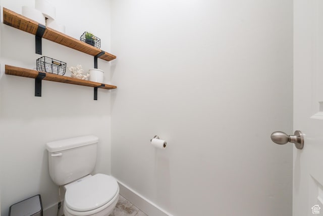 bathroom with marble finish flooring, baseboards, and toilet