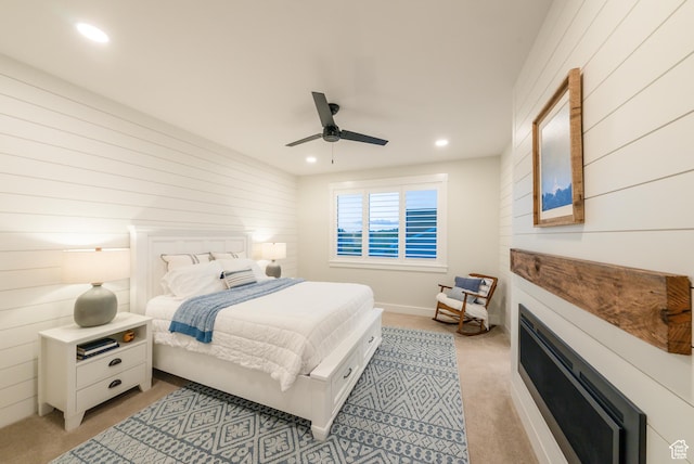 bedroom featuring light colored carpet, wooden walls, recessed lighting, and ceiling fan