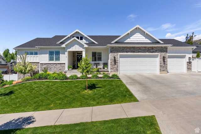 craftsman inspired home with stone siding, board and batten siding, an attached garage, and driveway